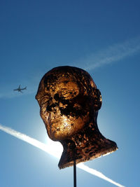 Low angle view of bird statue against clear blue sky