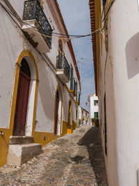 Footpath amidst buildings against sky