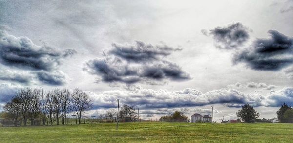 Scenic view of grassy field against cloudy sky