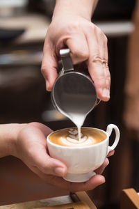 Close-up of woman pouring coffee in cup