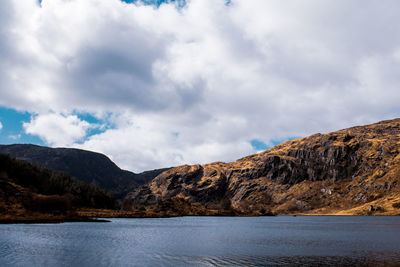 Scenic view of lake by mountains against sky