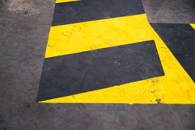 High angle view of yellow arrow sign on road