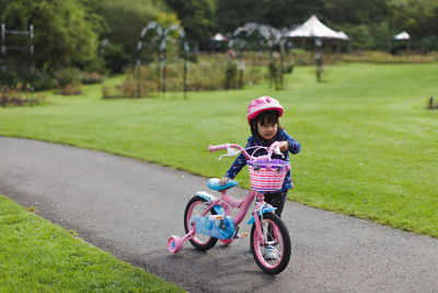 Girl walking with bicycle in park