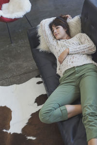 High angle view of woman lying on sofa