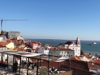 High angle view of town by sea against clear sky