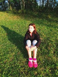 Portrait of smiling young woman sitting on field