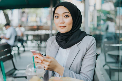 Portrait of young woman using mobile phone