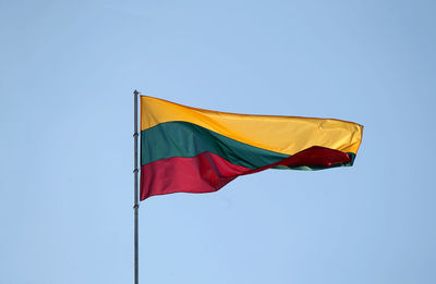 Low angle view of flags flag against clear blue sky