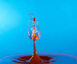 Close-up of liquid splashing against blue background