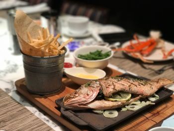 Close-up of fish food and french fries served on table