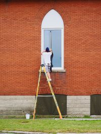 Man standing against brick wall