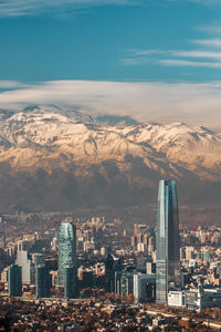 Aerial view of cityscape against snowcapped mountains