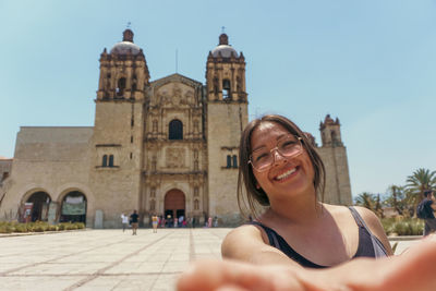 Low angle view of woman standing against historic building