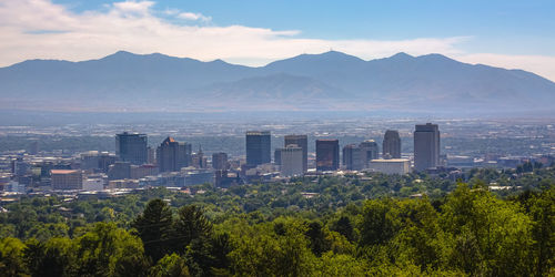 Scenic view of city and mountains against sky