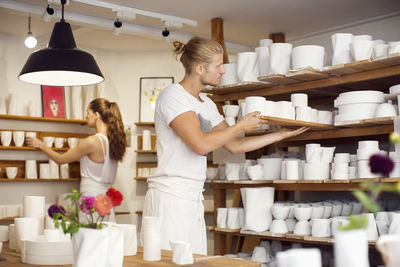 Workers arranging craft products at crockery workshop