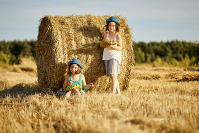 Siblings standing on field