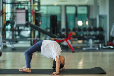 Girl doing yoga on floor in gym