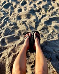 Low section of man relaxing on sand
