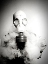 Person wearing gas mask against wall