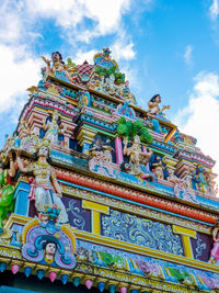 Low angle view of statues on building against sky