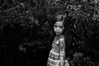 Digital composite image of spooky girl standing by plants