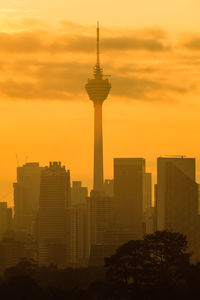 Modern buildings against sky during sunset