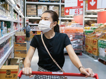 Full length portrait of woman standing at store