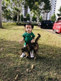 Portrait of baby girl with her cat at city garden 