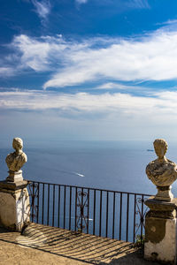 Statue by sea against sky