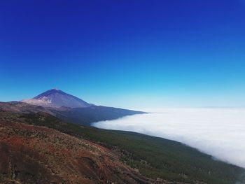 Scenic view of mountain against blue sky