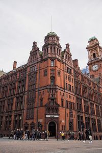 Group of people in front of historical building against sky