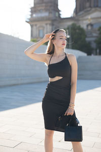 Portrait of young woman standing in city