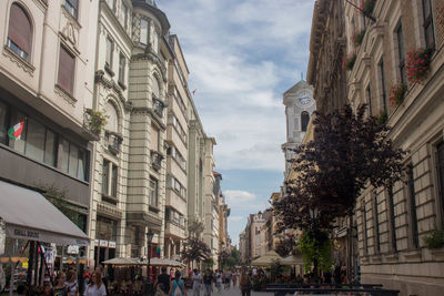 People on street amidst buildings in city