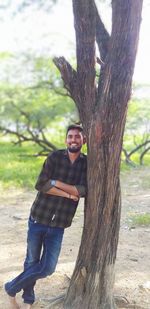 Portrait of young man on tree trunk