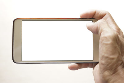 Midsection of person holding smart phone against white background