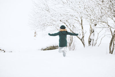 Young woman walking in snow