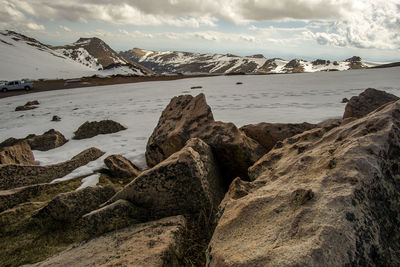 Scenic view of sea by snowcapped mountains against sky