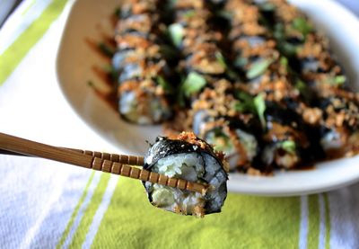 High angle view of chopsticks with sushi over table