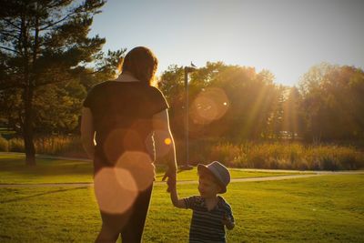Mother and son on grassy field in park