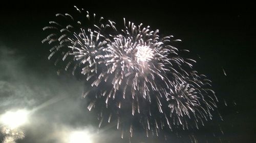 Low angle view of firework display at night