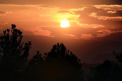 Scenic view of silhouette trees against romantic sky at sunset