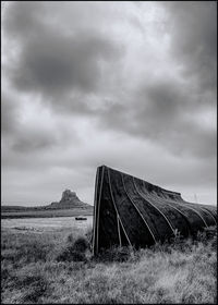 Abandoned car on field against sky