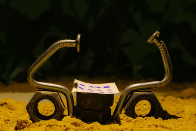 Close-up of nut and bolts on sand at night