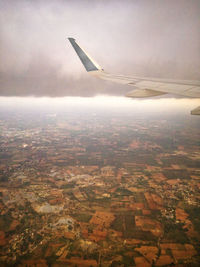 Airplane flying over landscape against sky