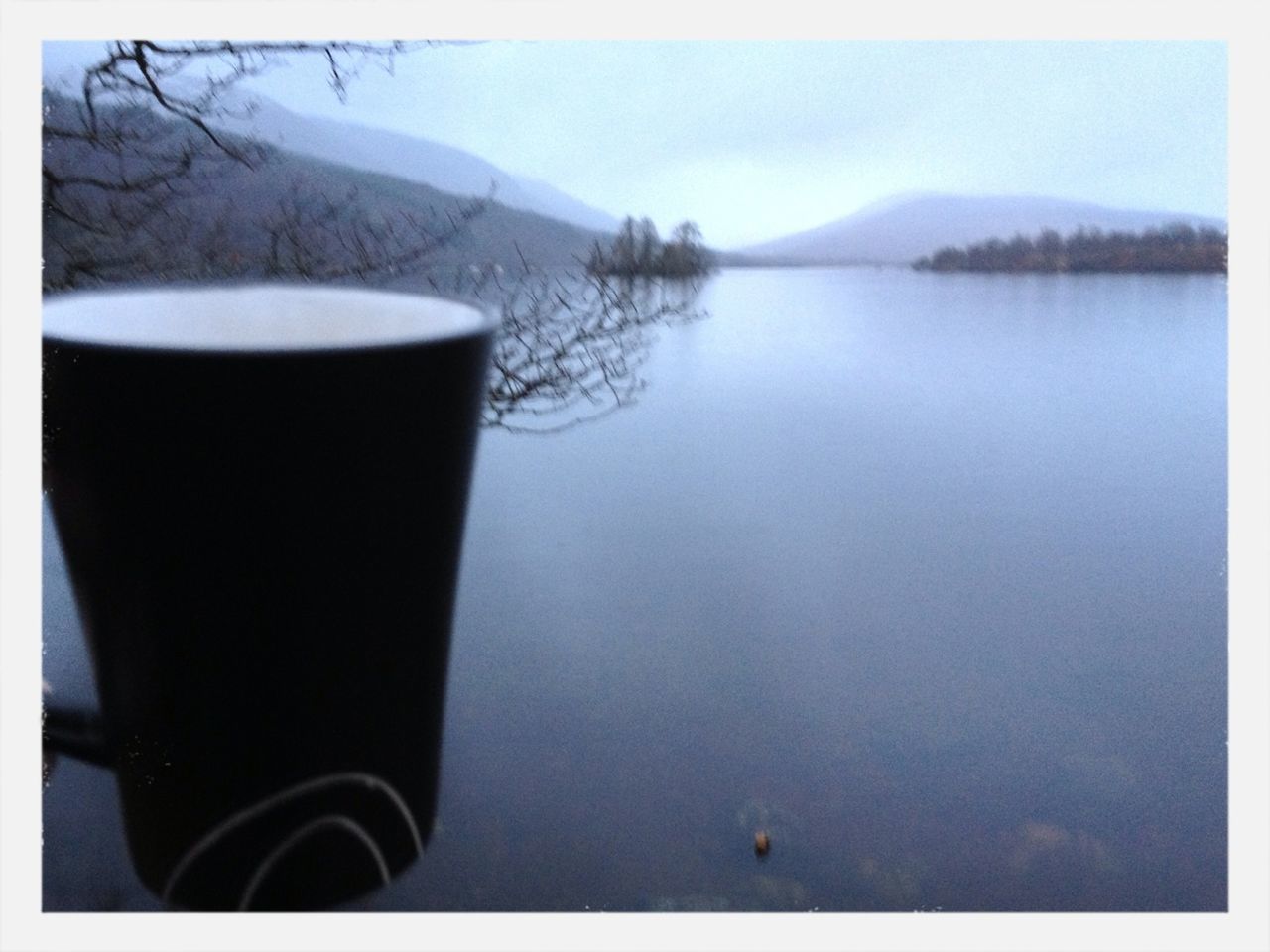 water, transfer print, drink, auto post production filter, lake, reflection, refreshment, sky, tranquil scene, tranquility, food and drink, scenics, mountain, nature, outdoors, beauty in nature, calm, coffee cup, no people, table