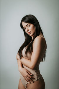 Portrait of beautiful young woman against white background