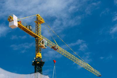 Low angle view of crane against sky