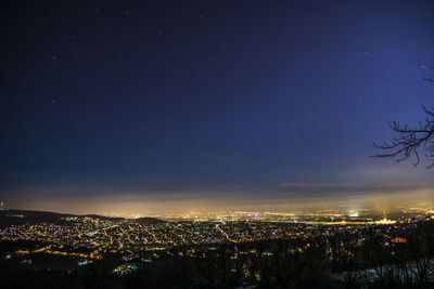 Aerial view of illuminated cityscape against sky at night