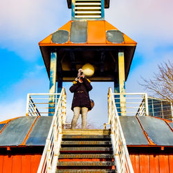 Low angle view of man standing on staircase against building