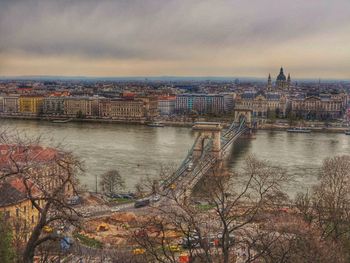 Bridge over river against cloudy sky